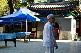 Chine : un homme installe les tables pour la rupture du jeûne dans la cour de la mosquée.