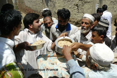 Au centre de la photo (col bleu), Inayat Ur Rehman, le coordonnateur de projets sur place du SIF, distribue les repas.