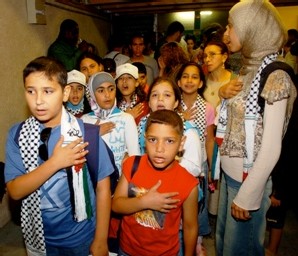 Ali (à gauche) et Khalid (à droite), accompagnés du groupe, chantent l'hymne national palestinien.