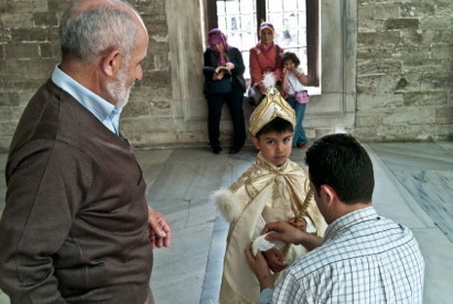 A la moquée d'Eyub, à Istanbul, devant son grand-père, un père prépare son enfant avant la circoncision. L'enfant porte la tenue traditionnelle pour ces occasions. © 2011 Michael Fuery - Agence: iStockPhoto.