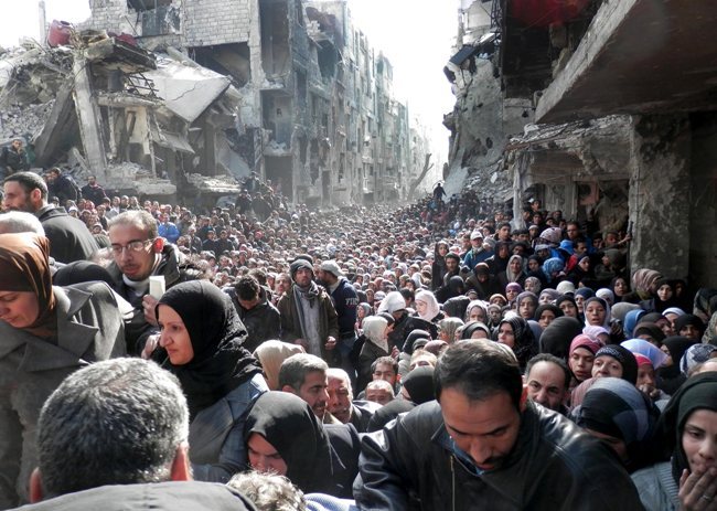 Des centaines de Palestiniens du camp de Yarmouk, en Syrie, se dirigeant vers un point de distribution de nourriture le 31 janvier. © UNRWA