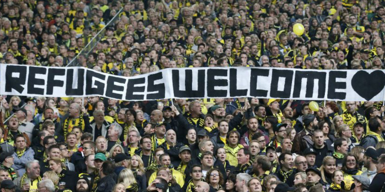 Les supporters du Borussia Dortmund adressant un message de bienvenue aux réfugiés. Les supporters du Borussia Dortmund adressant un message de bienvenue aux réfugiés.