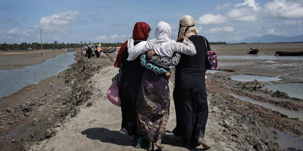 Trois femmes rohingyas ayant fui la Birmanie en traversant la rivière Naf marchent vers un camp de réfugiés situé à Teknaf, dans le district de Cox's Bazar, au Bangladesh.  ©Anastasia Taylor-Lind/HRW