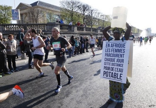 La Gambienne Siabatou Sanneh a pris le départ du marathon de Paris, dimanche 12 avril, avec un bidon sur la tête pour sensibiliser l'opinion publique aux longues distances parcourus en Afrique pour accéder à l'eau. © AFP