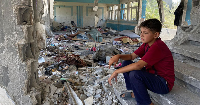 Un enfant palestinien assis au milieu des débris à Nuseirat, dans la bande de Gaza. © 2024 UNRWA