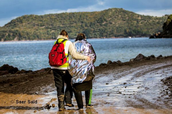 Une bénévole réconforte et accompagne une dame au camp des premiers soins. Lesbos (Grèce), octobre 2015. © Saer Saïd
