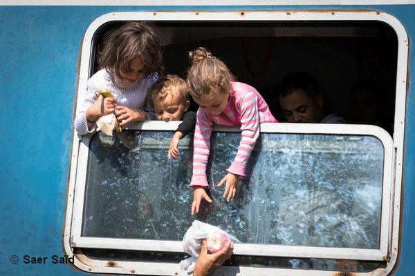 Des enfants essayent difficilement de récupérer des colis alimentaires distribués par les humanitaires. Zakany (Hongrie), octobre 2015.