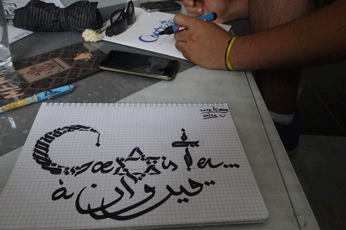 Le logo de Coexister calligraphié par le graphiste Khalilo Ayed à Kairouan, pendant le voyage effectué par Christophe Cadiou, Héléna Houard et Saïkou Camara en Tunisie du 1er au 9 juillet, première étape de leur InterFaith Tour Africa.